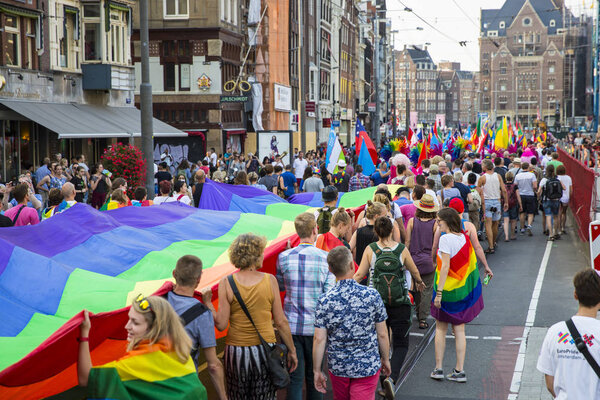 Amsterdam, the Netherlands - July 23, 2016: Pride Walk, Raimbow flag spread and held by people during the demonstration parade from Vondelpark to Dam Square during Pink Saturday Gay Euro Pride celebrations