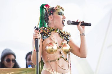 Amsterdam, Hollanda - 29 Temmuz 2017: Seksi parlak altın bikini ve steampunk kıyafetli sanatçı Westerpark'taki Milkshake Festivali'nde sahne alıyor