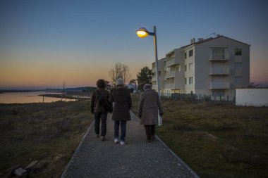 Geceleri yürüyen insanlar mavi ve sarı gökyüzüyle düşerler