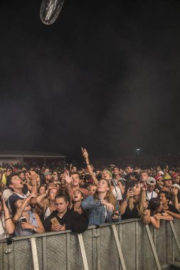 Nyon, İsviçre - 18 Temmuz 2017: Paleo Festivali'nde Fransız elektronik müzisyeni Petit Biscuit'in konserinde genç hayranların dinleyicileri