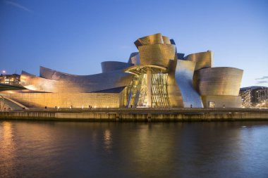 Bilbao, İspanya - 29 Ocak 2016: Amerikalı mimar Frank Gehry tarafından tasarlanan ve Ekim 1997'de açılışı yapılan modern ve çağdaş sanat Guggenheim Müzesi'nin gece manzarası.