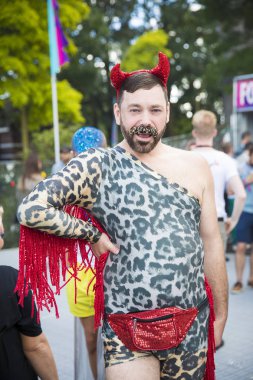 Amsterdam, Hollanda - 30 Temmuz 2017: Westerpark Milkshake Festivali'nde panter baskılı seksi üst, şeytan boynuzu kafa parçası ve ışıltılı bıyık ile giyinmiş adam