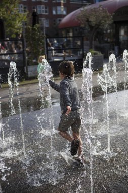 Amsterdam, Hollanda, 13 Eylül 2014, West'ival'de, Mercatorplein'de ücretsiz bir açık hava sinema ve kültür festivali, çeşmede eğlenen çocuk