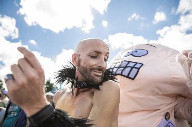 Amsterdam, The Netherlands - July 30 2017: bold man dancing with a  man in a penis costume at Milkshake Festival in Westerpark