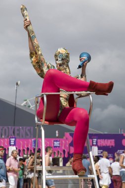 Amsterdam, Hollanda - 30 Temmuz 2017: Westerpark Milkshake Festivali'nde bir çeşit penisle süslenmiş, çiçek desenli entegre takım elbiseli mama sandalyelerinde oturmuş sanatçılar