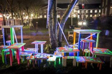 Amsterdam, the Netherlands December 20, 2015 : artwork with fluorescent piles up tables exhibited in the Hermitage garden at Amsterdam Light Festival 2015 which is dedicated to theme 'Friendship'