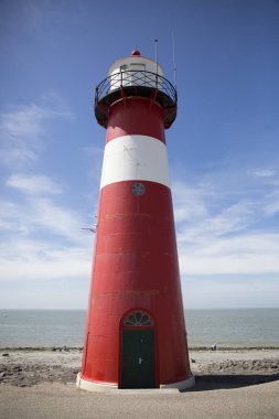 Mavi gökyüzü arka plan üzerinde kırmızı ve beyaz deniz feneri, Westkapelle, Hollanda