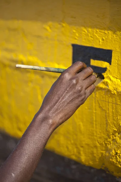 Preto Homem Mão Pintura Letteres Uma Superfície Madeira Pintada Amarelo — Fotografia de Stock