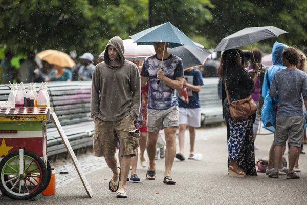 Amsterdam, The Netherlands - July, 5 2015: vistors walking under the rain during Amsterdam Roots Open Air, a cultural festival held in Park Frankendael on 05/07/2015