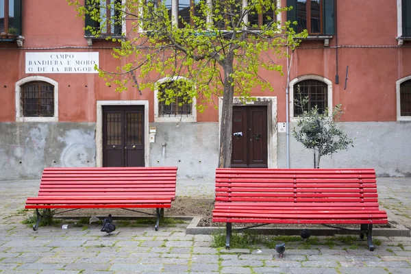 Två Röda Bänkar Liten Venetiansk Torg Med Rosa Bostadshus Bakgrunden — Stockfoto