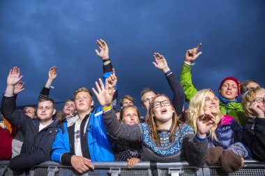 Traena, Norveç - 08 Temmuz 2016: Norveçli folk ve rock grubu Violet Road'un Traenafestival'deki konserinde seyirciler tezahürat yapıyor, Norveç'in küçük Traena adasında müzik festivali düzenleniyor