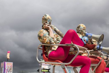 Amsterdam, Hollanda - 30 Temmuz 2017: Westerpark Milkshake Festivali'nde bir çeşit penisle süslenmiş, çiçek desenli entegre takım elbiseli mama sandalyelerinde oturmuş sanatçılar