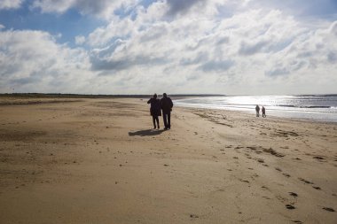 Vendee kumlu plaj, Fransa mavi gökyüzü ve beyaz bulutlar ve insanlar dolaşan
