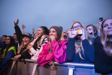 Traena, Norveç - 9 Temmuz 2015: Norveçli rock grubu Onklp & De Fjerne Slektningene'nin Traenafestival'deki konserinde silahla tezahürat taslayan hayranlar, traena adasında düzenlenen müzik festivali
