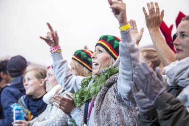 Traena, Norveç - 10 Temmuz 2015: Norveçli grup Kim Lie og hans Langt Nord Bandat the Traenafestival'in konserinde seyirciler havada kollarını kaldırdı.