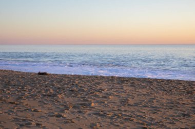 Sahilde romantik günbatımı ışığı ve bir kış akşamında el sallamak