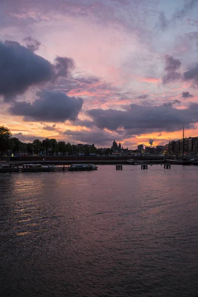 Amsterdam limanı üzerinde romantik mor gün batımı, Hollanda