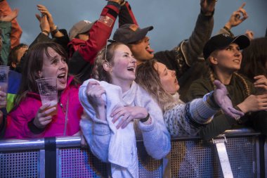 Traena, Norveç - 6 Temmuz 2017: Norveçli punk rock grubu Honningbarna'nın Traenafestival'deki konserinde seyirciler tezahürat, alkışlama ve dans etme, küçük Traena adasında düzenlenen müzik festivali
