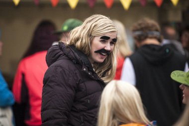 Traena, Norveç - 10 Temmuz 2015: Festival alanında sahte kaş ve bıyık takan genç kadın Traenafestival, traena küçük adada müzik festivali gerçekleşiyor