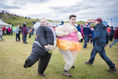 Traena, Norveç - 8 Temmuz 2017: Traenafestival'de şişme takım elbiseli sumo kılığına giren erkek ve kadın, traena adasında müzik festivali gerçekleşiyor