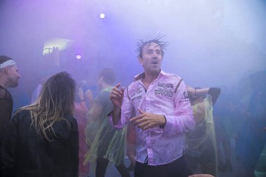 Amsterdam, Hollanda - 29 Temmuz 2017: Westerpark'taki Milkshake Festivali'nde yağmur ponçolarıyla yağmur altında dans eden insanlar