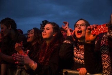 Traena, Norveç - 08 Temmuz 2016: Norveçli folk ve rock grubu Violet Road'un Traenafestival'deki konserinde seyirciler tezahürat yapıyor, Norveç'in küçük Traena adasında müzik festivali düzenleniyor