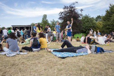 Amsterdam, Hollanda - 5 Temmuz 2015: Amsterdam Roots Open Air,Park Frankendael'de 05/07/2015 tarihinde düzenlenen kültür festivali sırasında etrafta dolaşıp çimlerin üzerinde yatan insanlar