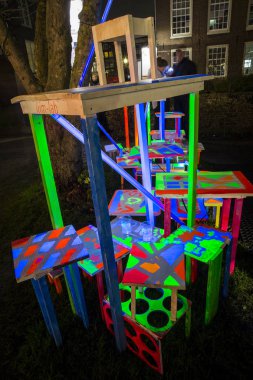 Amsterdam, the Netherlands December 20, 2015 : artwork with fluorescent piles up tables exhibited in the Hermitage garden at Amsterdam Light Festival 2015 which is dedicated to theme 'Friendship'