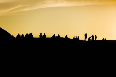 Traena Festivali 2014, bir tepenin tepesinde duran insanlar gece yarısı güneşini gölgeliyor