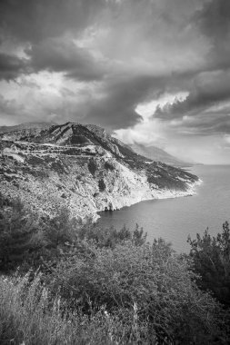 Dramatik bulutlu gökyüzü, Hırvatistan ile adriyatik denizinde aşağı gidiyor uçurumda siyah ve beyaz Havadan görünümü