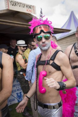 Amsterdam, Hollanda - 30 Temmuz 2017: Westerpark Milkshake Festivali'nde boynunda pembe bir telefon telefonu ve tek boynuzlu at şapkası asılı pembe giyinmiş adam