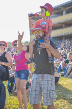 Nyon, İsviçre - 18 Temmuz 2017: Paleo Festivali'nde Fransız rock grubu Müfettiş Cluzo'nun konserini izlemek için babasının omzunda genç çocuk