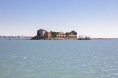 İtalya, Burano yakınlarındaki Venedik gölünde terk edilmiş eski turuncu tuğlalı evi olan küçük bir ada.