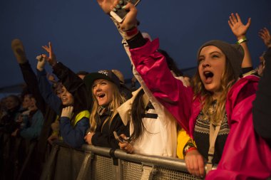 Traena, Norveç - 9 Temmuz 2015: Norveçli rock grubu Onklp & De Fjerne Slektningene'nin Traenafestival'deki konserinde silahla tezahürat taslayan hayranlar, traena adasında düzenlenen müzik festivali