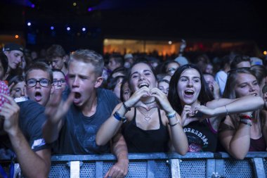 Nyon, İsviçre - 18 Temmuz 2017: Paleo Festivali'nde Fransız elektronik müzisyeni Petit Biscuit'in konserinde genç hayranların dinleyicileri
