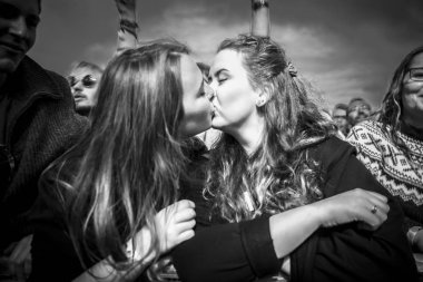 Traena, Norveç - 08 Temmuz 2016: Norveçli folk ve rock grubu Violet Road'un Traenafestival'deki konserinde ağızdan öpüşen iki kız, Norveç'in küçük Traena adasında müzik festivali düzenleniyor