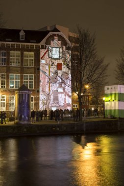 Amsterdam, the Netherlands December 20, 2015: animated video mapping artwork called Canal House from Irma de Vries exhibited at Amsterdam Light Festival 2015 which is dedicated to theme 'Friendship'