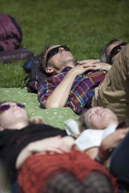 Amsterdam, Hollanda - 3 Temmuz 2016: Dünya müziği Namibyalı grup Shishani ve Amsterdam Roots Open Air'de Namibya Masalları konserinde çimlerin üzerinde yatan adam ve wonman, Oosterpark'ta düzenlenen ücretsiz halk kültür festivali