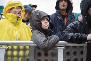 Traena, Norveç - 7 Temmuz 2017: Norveçli pop şarkıcısı Aurora'nın Traenafestival'deki konseri sırasında yağmur altında seyirciler arasında hayranlık uyandıran ve hayranlık uyandıran çocuk, traena adasında düzenlenen müzik festivali