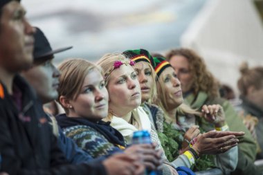 Traena, Norveç - 10 Temmuz 2015: Norveçli grup Kim Lie og hans Langt Nord Bandat the Traenafestival'in konserinde seyirciler arasında bayanlar havada kollarını kaldırdı, traena küçük adada müzik festivali gerçekleşiyor