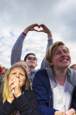 Traena, Norveç - 07 Temmuz 2016: Norveçli şarkıcı Astrid S'nin Traenafestivalen'deki konserinde seyircilerin arasında kalp şeklinde el kaldıran adam, traena adasında düzenlenen müzik festivali