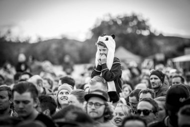 Traena, Norveç - 07 Temmuz 2016: Norveçli şarkıcı Astrid S'nin Traenafestivalen'deki konserinde babasının omzunda küçük çocuk, traena adasında müzik festivali gerçekleşiyor