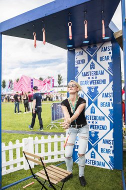 Amsterdam, Hollanda - 29 Temmuz 2017: Westerpark'taki Milkshake Festivali'nde düşen penisi yakalaması gereken bir oyunu oynarken eğlenen kadın