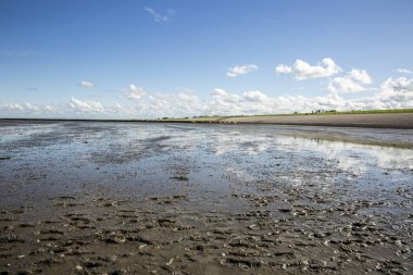 Deniz manzarası bulutların alçak gelgit sularındaki yansıması, Waddenzee, Friesland, Hollanda