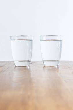 Ahşap bir masa üzerinde duran temiz sağlıklı su 2 tam bardak