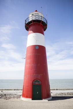 Mavi gökyüzü arka plan üzerinde kırmızı ve beyaz deniz feneri, Westkapelle, Hollanda
