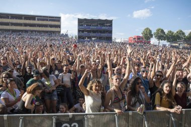 Nyon, Switzerland - 20 July 2017:  crowd of fans cheering at concert of French ska band Tryo at Paleo Festival clipart