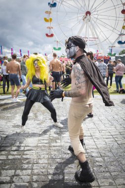 Amsterdam, Hollanda - 30 Temmuz 2017: Westerpark'taki Milkshake Festivali'nde dans eden insanları giydirdi. Bir kadın sarı bir peruk ve bir adam bir steampunk kıyafeti giyiyor