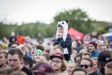 Traena, Norveç - 07 Temmuz 2016: Norveçli şarkıcı Astrid S'nin Traenafestivalen'deki konserinde babasının omzunda küçük çocuk, traena adasında müzik festivali gerçekleşiyor