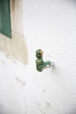 Beyaz duvar, klasik kepenkli salıncak, insan şeklinde.